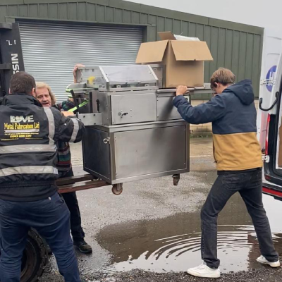three men lifting a machine